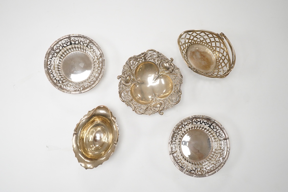 A pair of pierced silver circular bonbon dishes, maker JM, Birmingham, 1906, diameter 10.3cm, together with one other silver bonbon dish and two bonbon baskets, one silver, one stamped with U.S. sterling marks, 7.1oz.